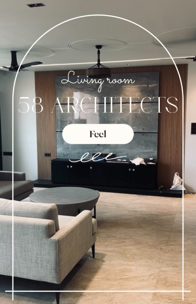 Modern living room interior design with sectional sofa, large windows and city view in Mumbai apartment